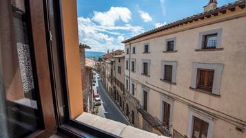 Une rue étroite, bordée de bâtiments des deux côtés, un ciel dégagé et une chaîne de montagnes lointaine.