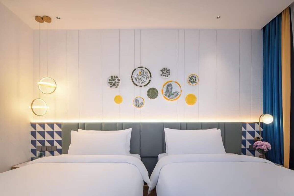 Un letto matrimoniale con testiera, una lampada a parete e un elemento decorativo a parete.