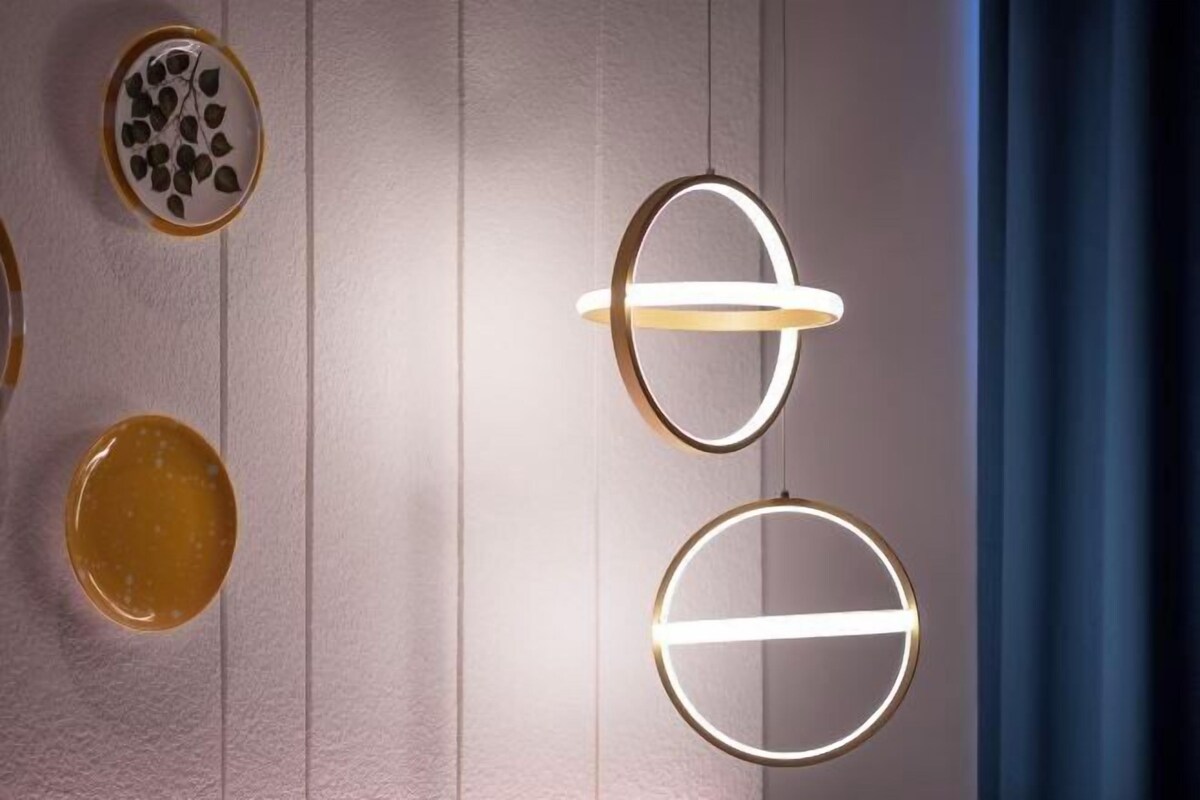 Un muro con tre lampade circolari e un piatto decorativo con pietre.