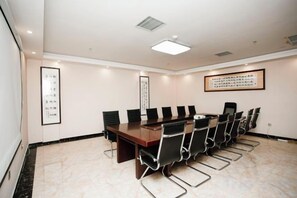 A conference room with a long table, chairs, and framed calligraphy on the walls. - Puyang Qianyou Hotel (Puyang)