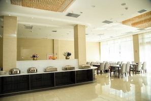 A hotel reception area with a counter, chairs, and a large window. - Puyang Qianyou Hotel (Puyang)