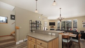 A modern kitchen with a central island, wooden cabinetry, and pendant lighting. - Winterstar Building A #6 3 bedroom views, Pet friendly common area HT (Fraser)