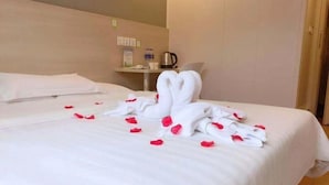 A hotel room with a neatly made bed, a bedside table with a kettle, and a wall clock. - Hi Inn (Shanghai Jinqiao Yanggao Middle Road) (Shanghai)
