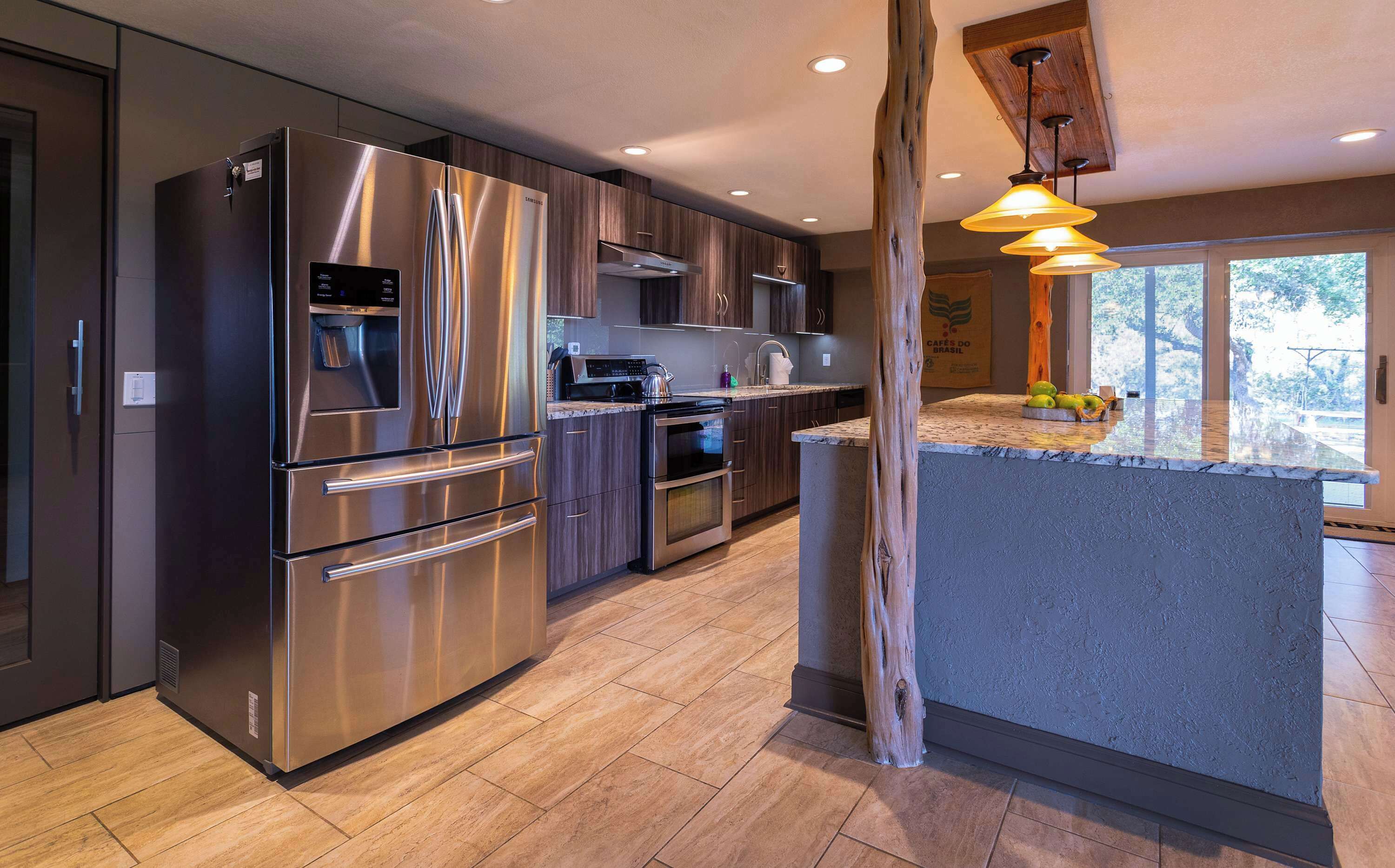 A modern kitchen with stainless steel appliances, wooden cabinets, and a large island with a built-in sink.