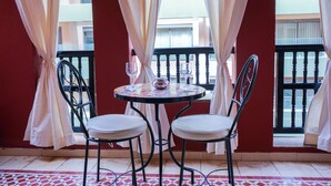 A balcony with a table and two chairs, a glass, and a teapot. - Superb luxury apartment with terrace in Gueliz Marrakech (Marrakech)