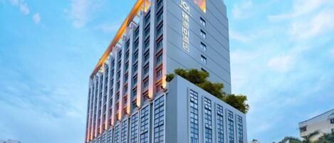 Een modern hoog hotel met meerdere verdiepingen, grote ramen en een opvallende ingang.