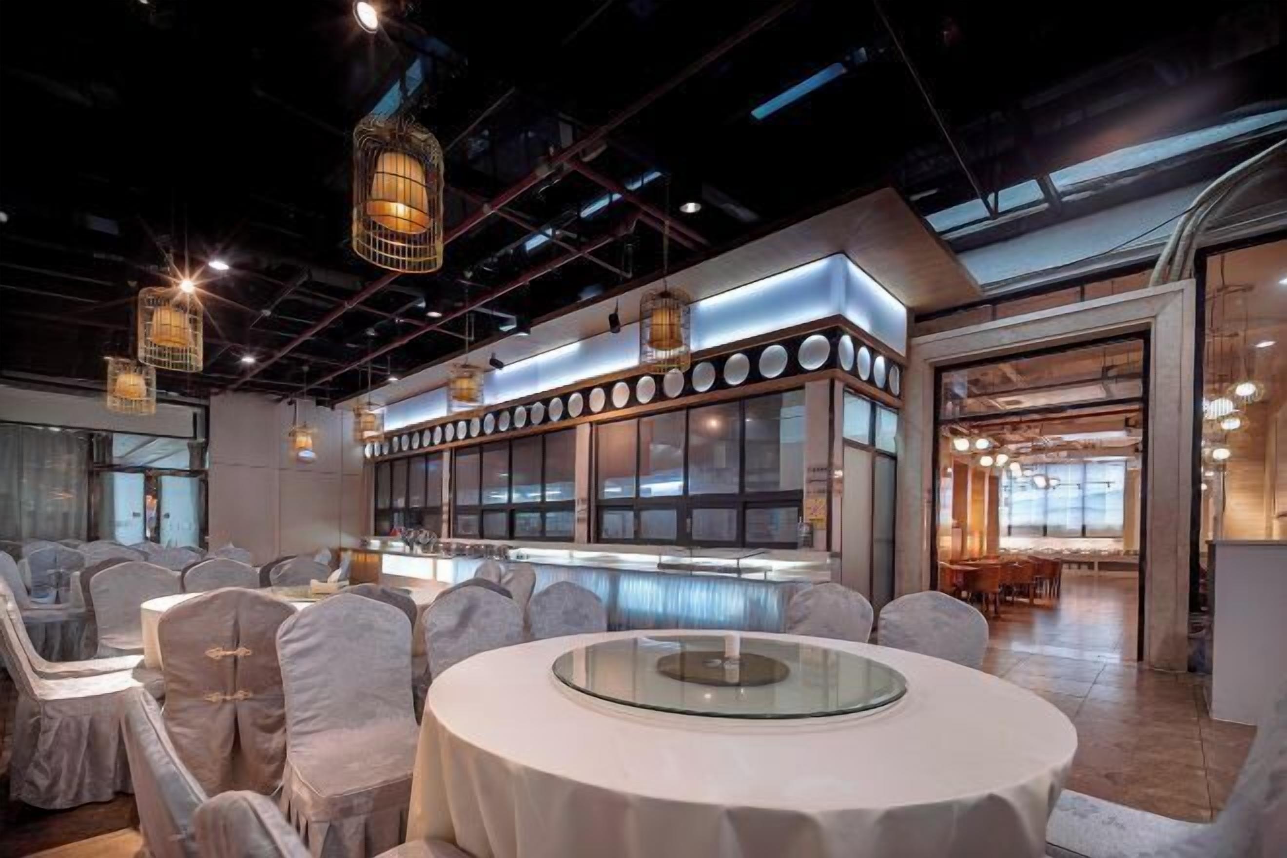 A modern conference room with round tables, white chairs, and a glass-top table.
