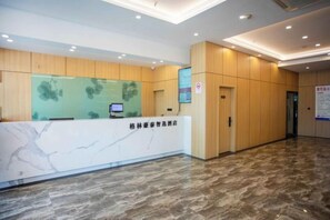A reception area with a marble counter, wooden paneling, and a digital screen. - GreenTree Inn Express Hotel(Shanghai Luoqian) (Shanghai)