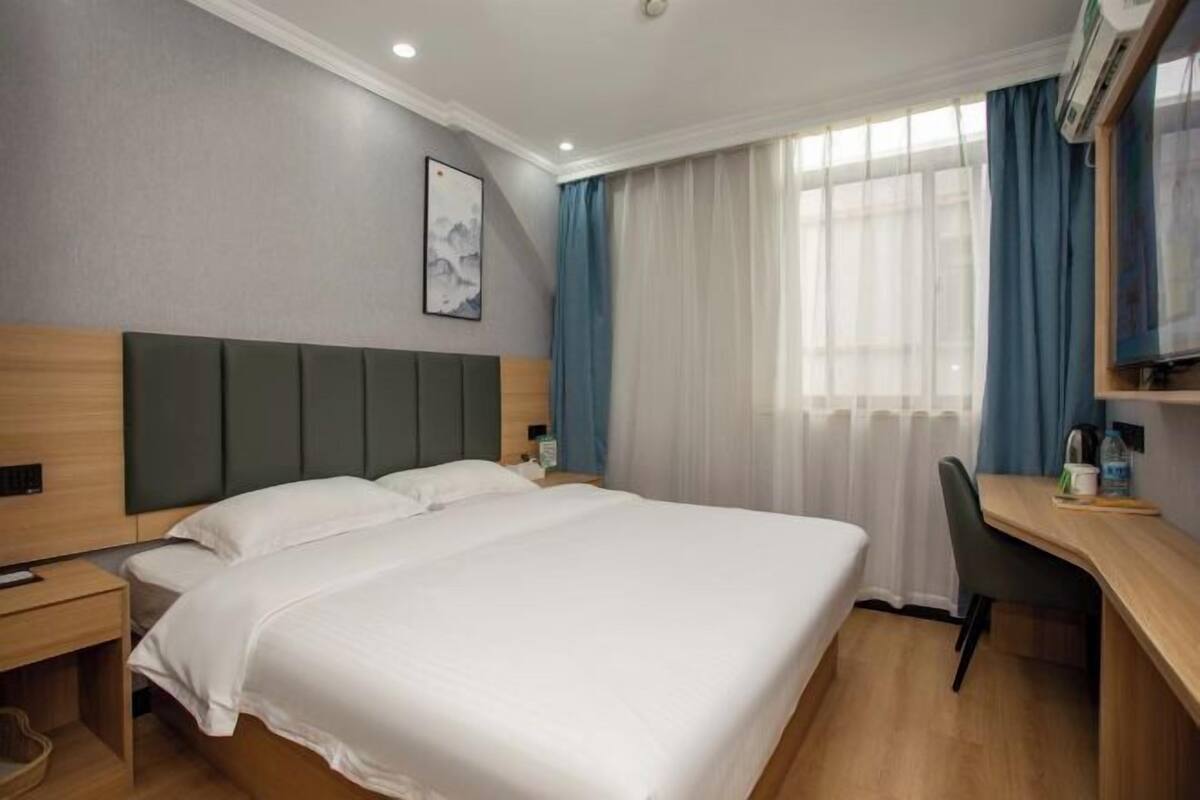 Una habitación de hotel con una cama grande, un escritorio y una silla.