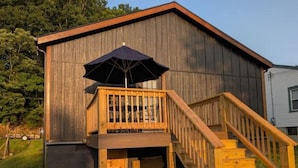 A wooden building with a balcony and a staircase leading to a deck area. - The Hawthorne Place (Buena Vista)