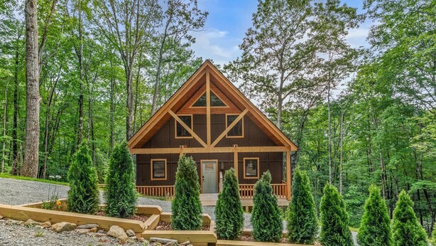 A cabin with a symmetrical design, a front porch, and a gravel driveway. - Bear Necessities - Hot tub, Pet Friendly, Games, Fire table, Beech Mtn (Beech Mountain)