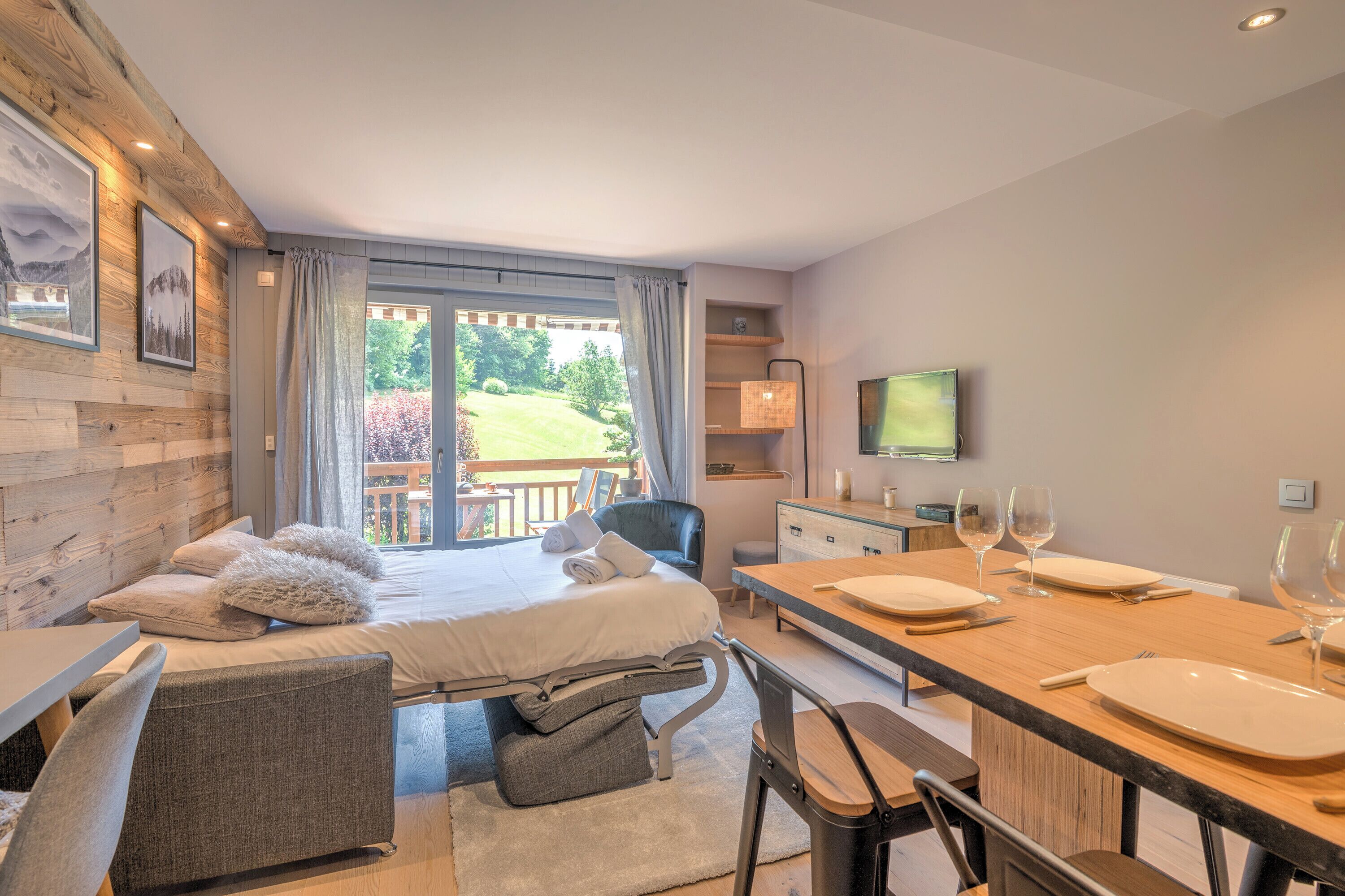 Une chambre à coucher moderne avec un lit, une table de chevet et une vue sur un jardin.