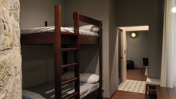 A room with bunk beds, a wooden table, and a patterned rug.
