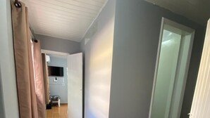Un pasillo con piso estampado, una puerta blanca y una pared azul claro.