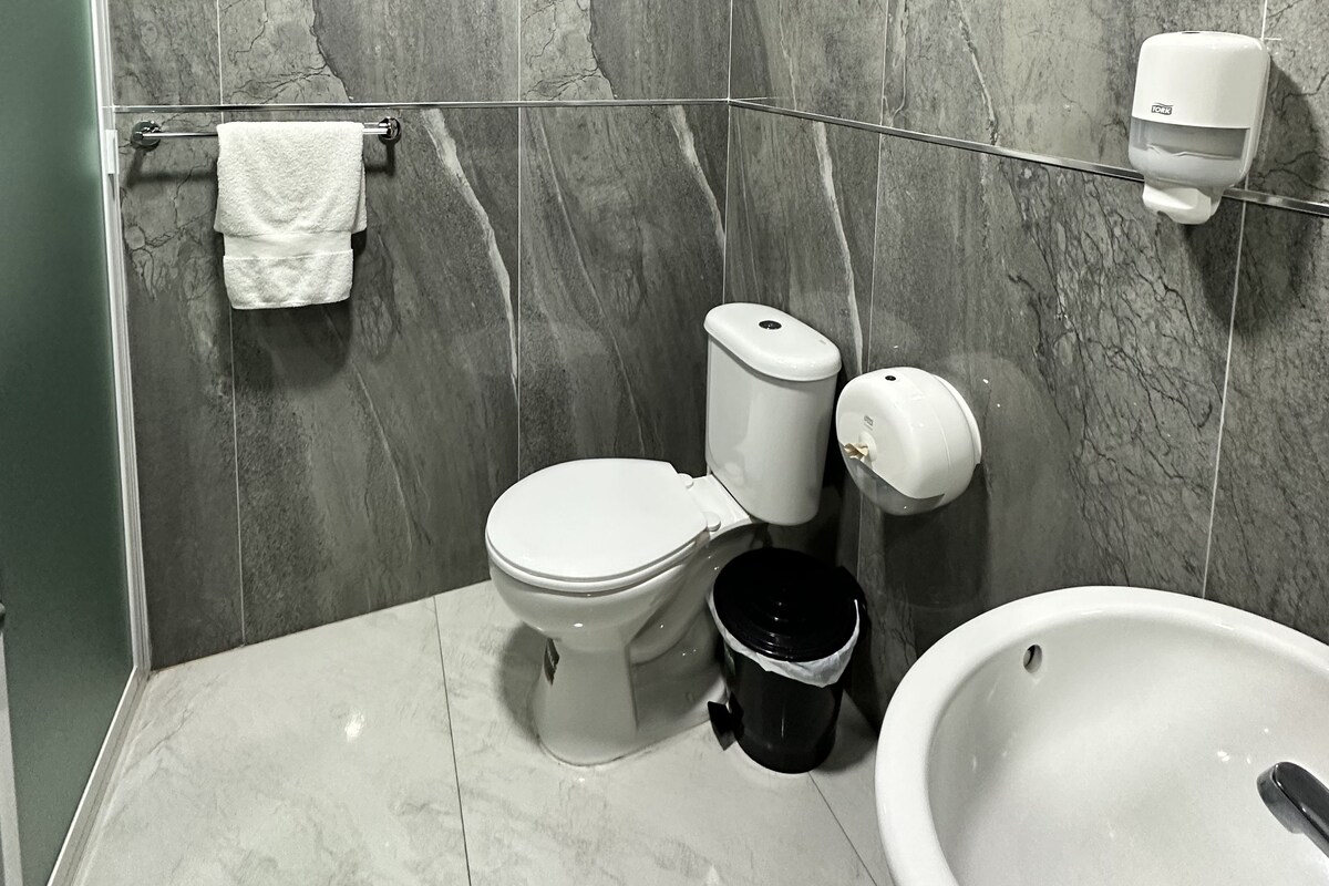A modern bathroom with a toilet, bidet, and bathtub.