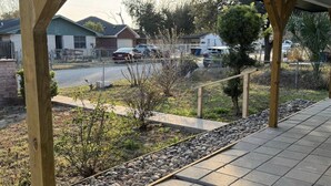 Un espace extérieur abrité, doté d’un sol carrelé et de piliers en bois.