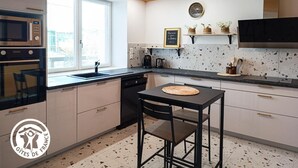 Eine moderne Küche mit Fenster, integrierten Geräten, einem schwarzen Barhocker und einer Tafel mit einer Nachricht.