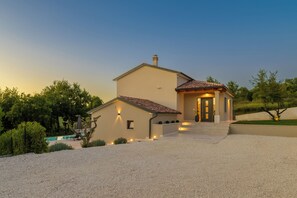 A two-story house with a tiled roof, a front porch, and a gravel driveway. - Villa Arboreta (Istria - Rovinj) (Gržini)