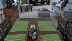 A dining area with a wooden table, green placemats, and a central decorative bowl. - Marina Across the Street! Park your boat & Trailor here! (Ludington)
