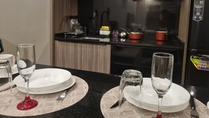 Une table à manger dressée avec des assiettes, des verres et des couverts dans une cuisine moderne.