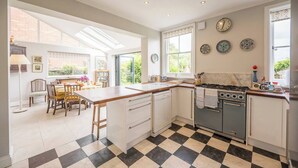 A modern kitchen with a central island, a dining area with a view, and a checkered floor.