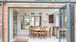 A dining area with a table set for four, surrounded by wooden chairs.