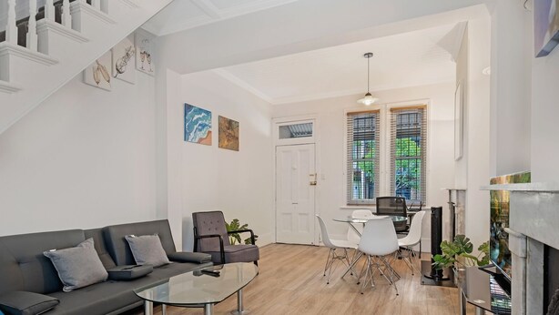 A modern living room with a sofa, coffee table, and dining area.