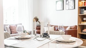 Une table à manger dressée avec de l’assiette blanche, des verres et un chandelier.