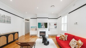 Una sala moderna con chimenea, un sofá rojo y una estatua de perro.