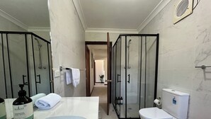 A modern bathroom with a large bathtub, a glass-enclosed shower, and a toilet. - KozyGuru | Thornleigh | Charming Two-Bed Townhouse (Thornleigh)