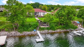 A lakeside property with a dock, a stone pathway leading to a house, and lush greenery. - "The Luxe" on Lake Carlos (Carlos Township)