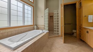 A bathroom with a large bathtub, a shower with glass doors, and a toilet. - "The Luxe" on Lake Carlos (Carlos Township)