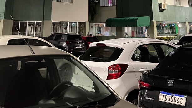 Uma garagem de estacionamento com vários andares e diversos carros estacionados.