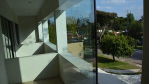 A modern building with a glass facade, a visible outdoor area with trees, and a clear sky. - hermosa residencia en ajijic con vista al lago (Ajijic)
