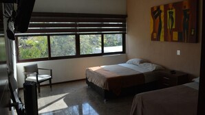 A hotel room with a large window, a bed, a chair, and a painting on the wall. - hermosa residencia en ajijic con vista al lago (Ajijic)
