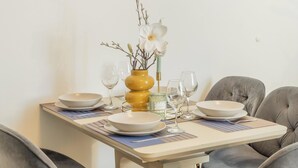 A dining table set with plates, glasses, and a vase with flowers. - Washington by Interhome (Prague centre)