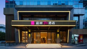 A hotel entrance with a modern facade, large glass windows, and a prominent signage. - Echarm Plus International Hotel Hangzhou Binjiang XingGuang Avenue Pedestrian Street Branch (Hangzhou)