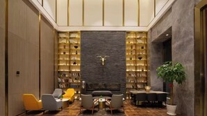 A modern interior with a fireplace, bookshelves, and seating areas. - Echarm Plus International Hotel Hangzhou Binjiang XingGuang Avenue Pedestrian Street Branch (Hangzhou)