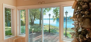 A room with large windows overlooking a lake, a balcony with a railing, and a decorative wall.