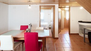 Une cuisine moderne avec une table en bois, des chaises rouges et un aquarium en verre.