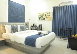 Una habitación de hotel moderna con una cama grande, un escritorio y una silla.