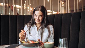 A person seated at a table with a bowl of food and a cup of coffee, in a restaurant with a modern interior and dark seating. - Distinction Invercargill Hotel (Invercargill)