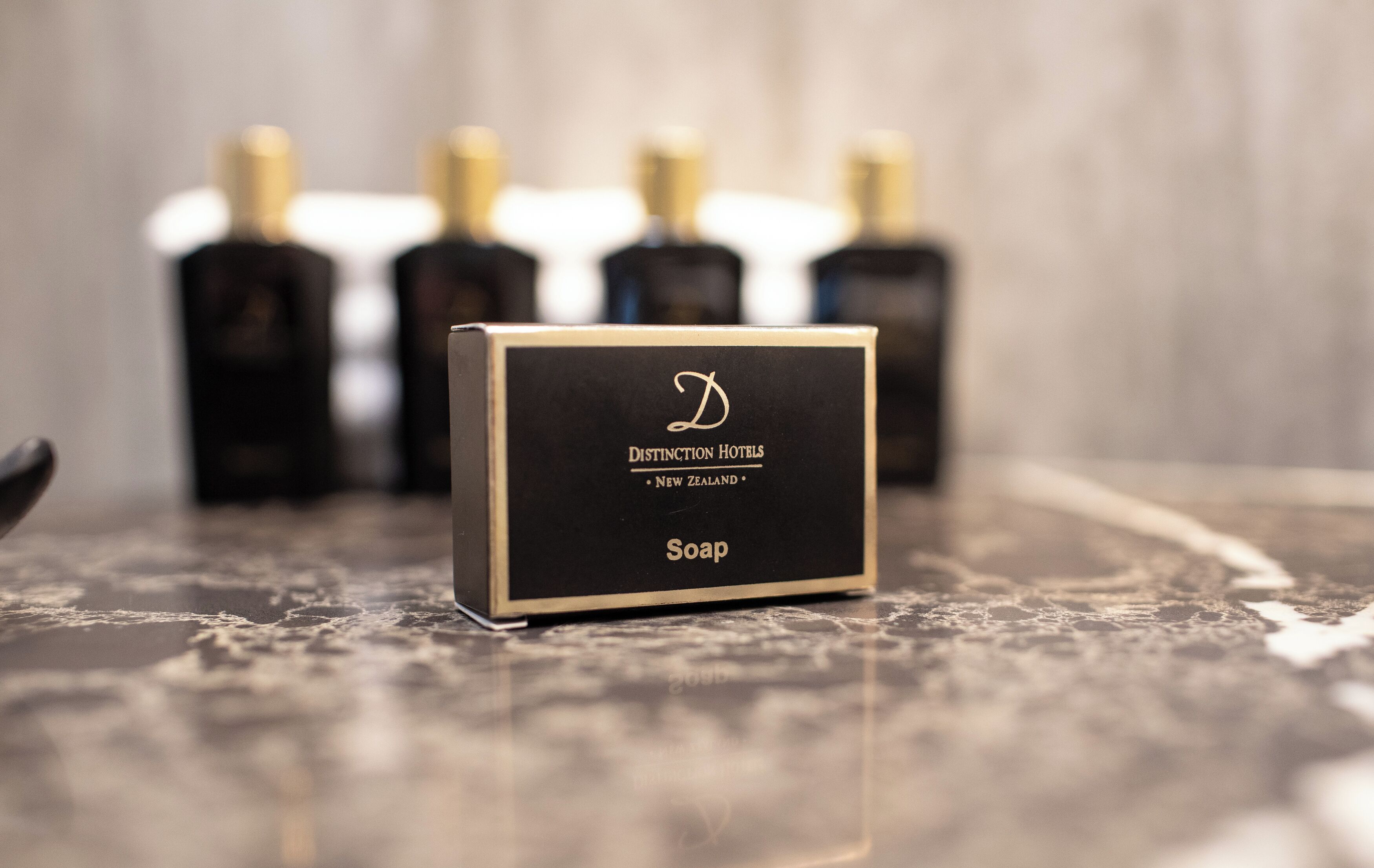 Een zeepbak met een logo en tekst die aangeeft dat deze van Distinction Hotels in Nieuw-Zeeland komt.