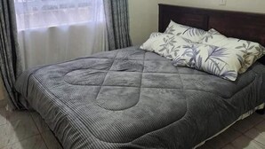 Une chambre à coucher avec un lit, des rideaux et une fenêtre.