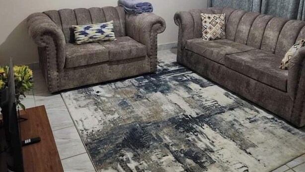 Un salon avec deux canapés, une table basse et un tapis.