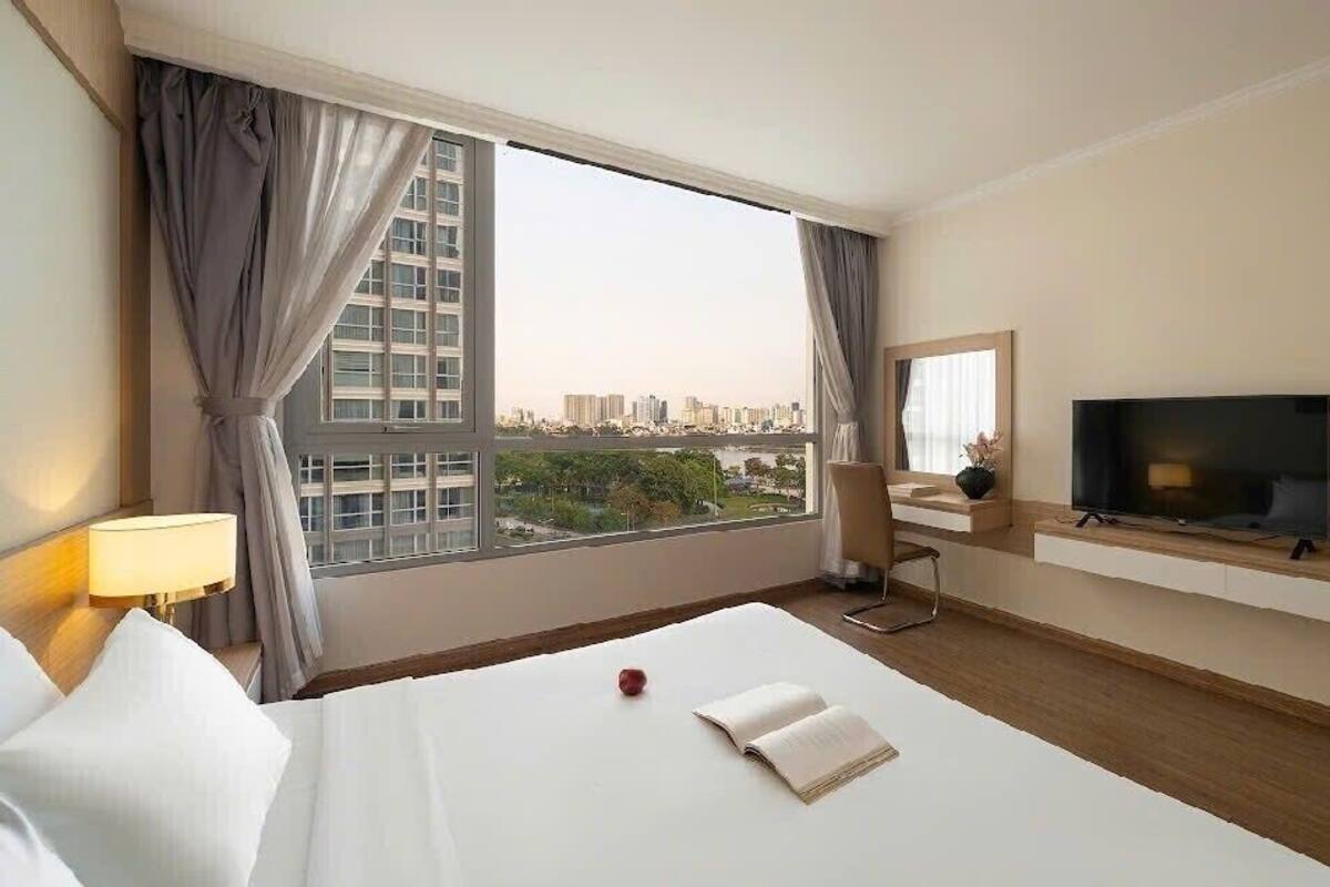 Een hotelkamer met een groot raam, een bed, een televisie en een stoel.