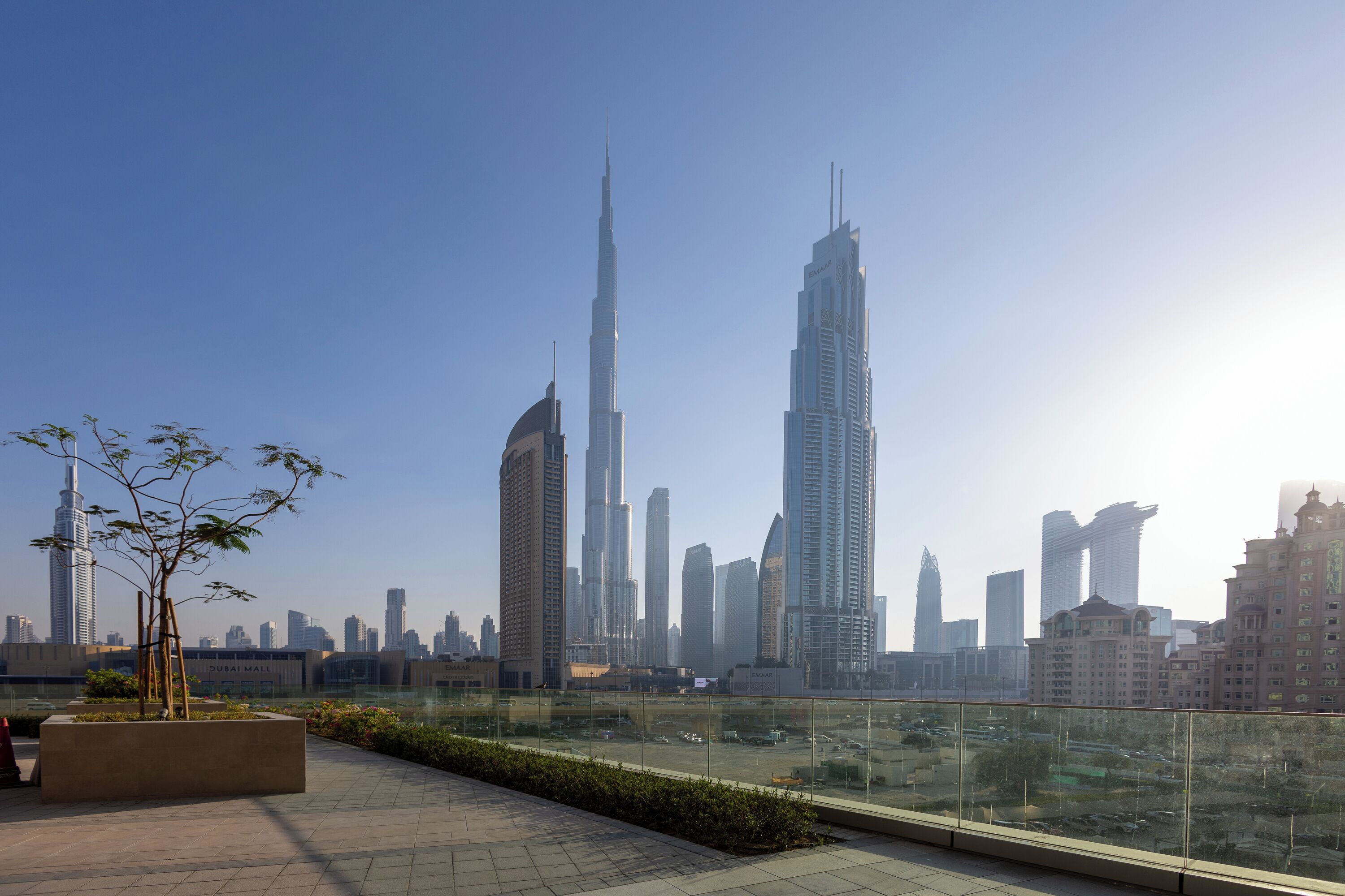 A cityscape with prominent skyscrapers, including the Burj Khalifa, and a clear sky.