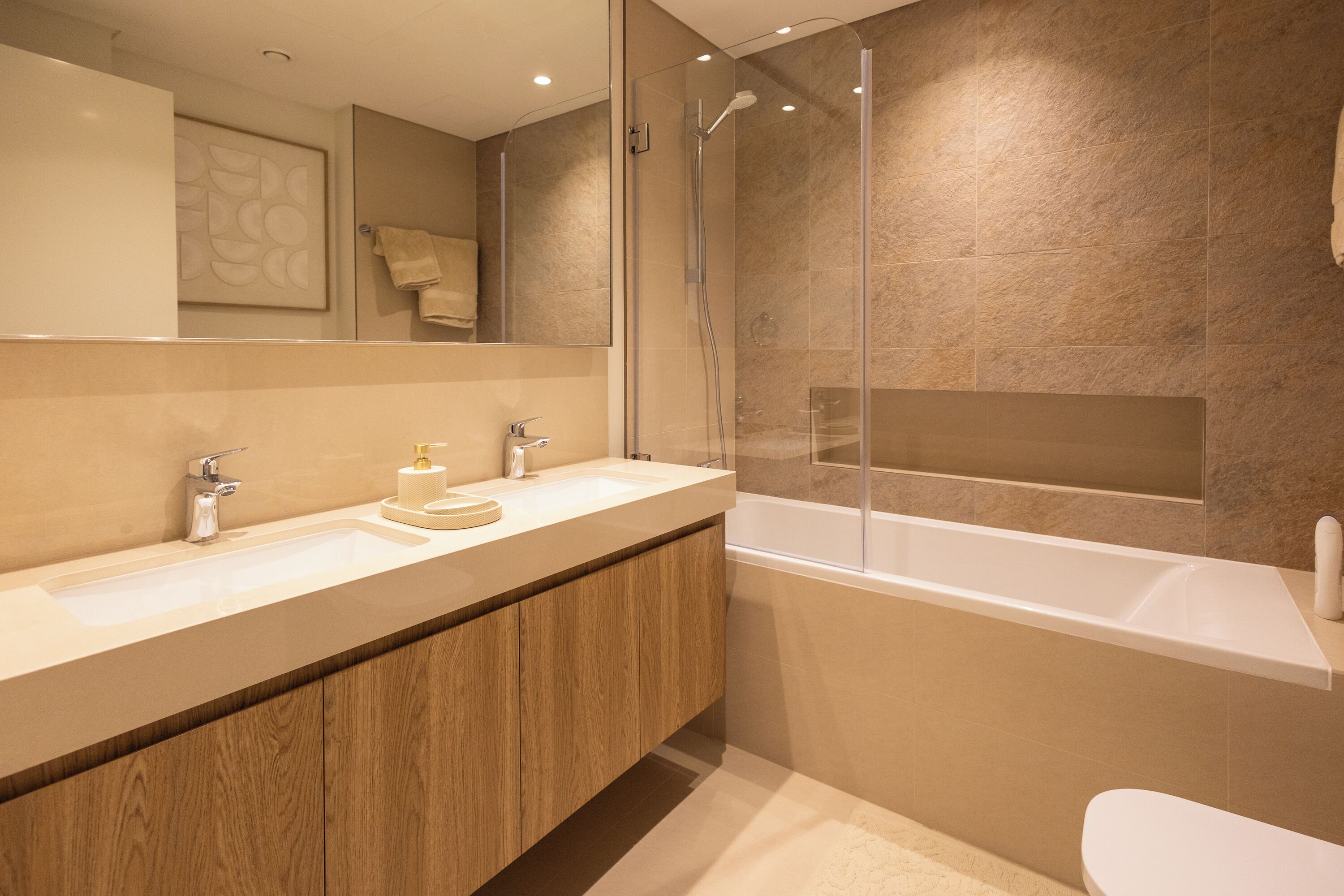 A modern bathroom with a wooden vanity, a large mirror, a bathtub, and a shower enclosure.