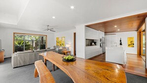 A modern kitchen with white cabinetry, a wooden countertop, and a built-in oven. - El Cid - Jervis Bay Beach House (Vincentia)
