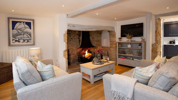 Una sala de estar acogedora con chimenea, asientos cómodos y televisor.